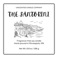 Label for 'The Santorini' unscented candle by the Unscented Candle Company with a scenic illustration.