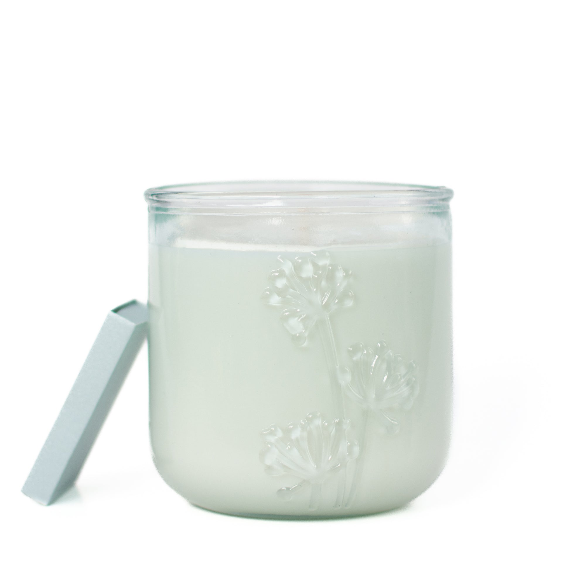 Close up of embossed wildflower detail, The Seville soy candle in recycled glass by Unscented Candle Company