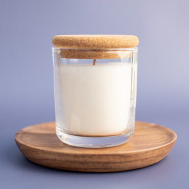 Unscented candle in a glass jar with a cork lid on a purple background
