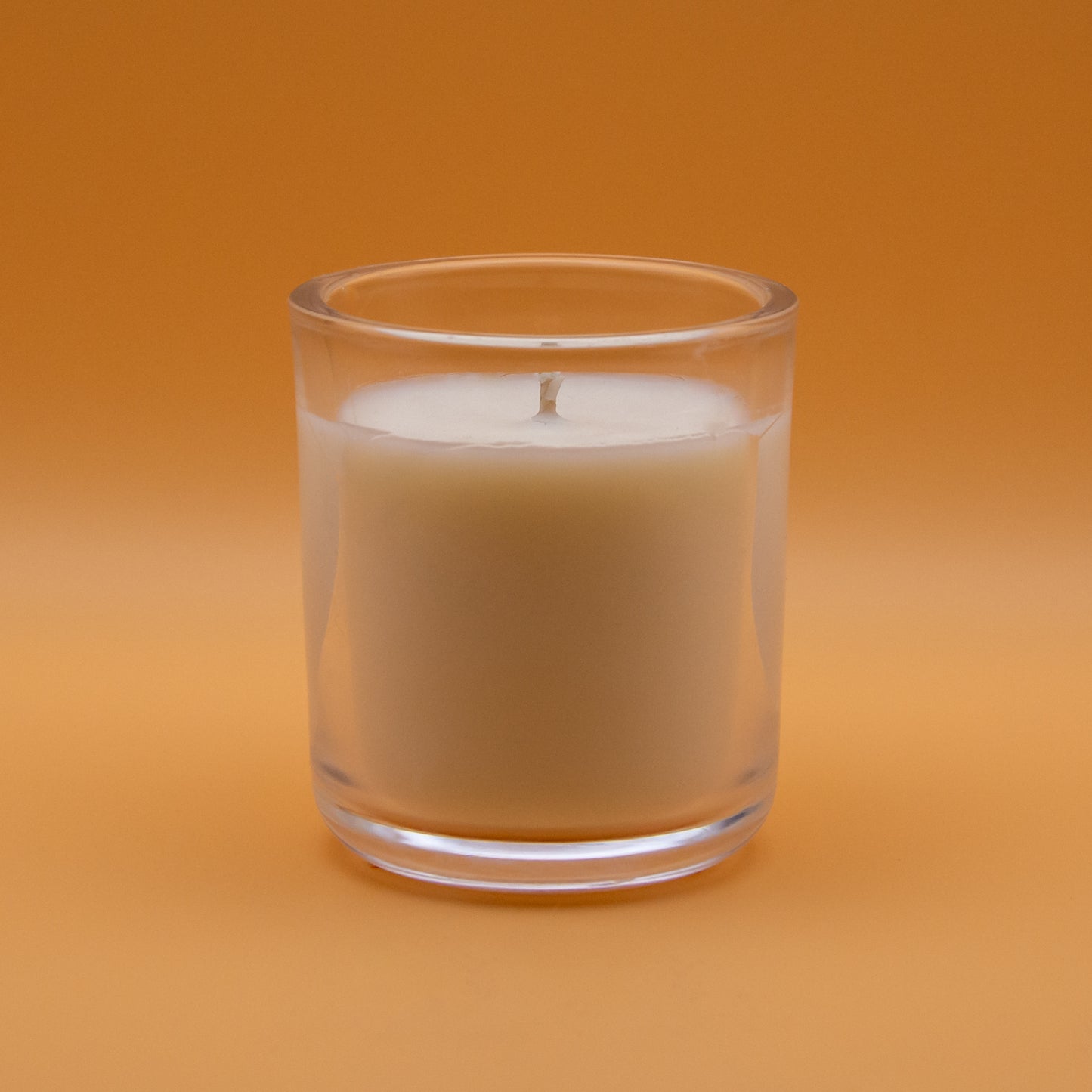 The Unscented Candle Company votive candle on peach background
